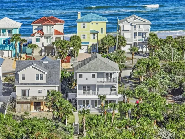 an aerial view of a residential apartment building with a yard and large trees