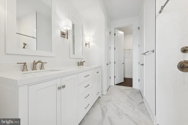a spacious bathroom with a double vanity sink mirror and shower