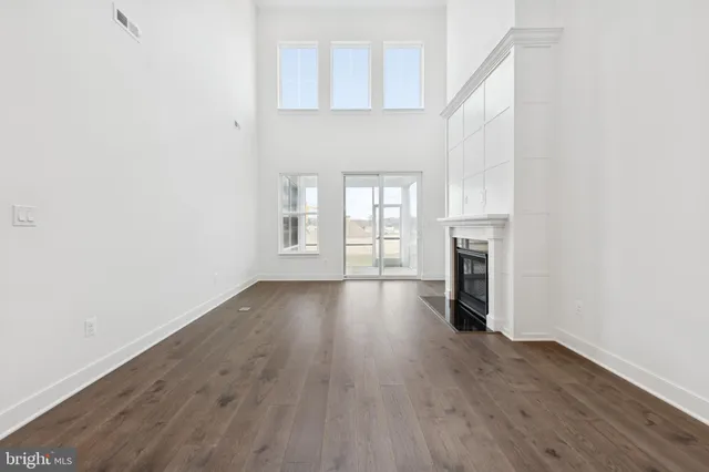 an empty room with wooden floor and fireplace