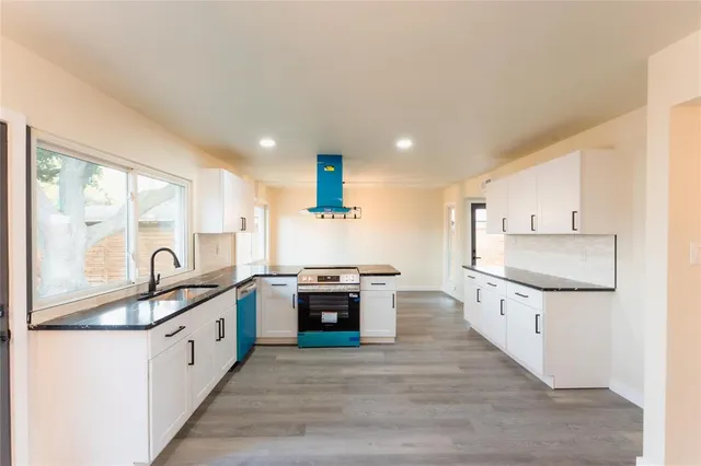 a large kitchen with stainless steel appliances granite countertop a stove and a sink