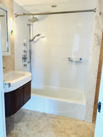 a bathroom with a bathtub a shower and a sink