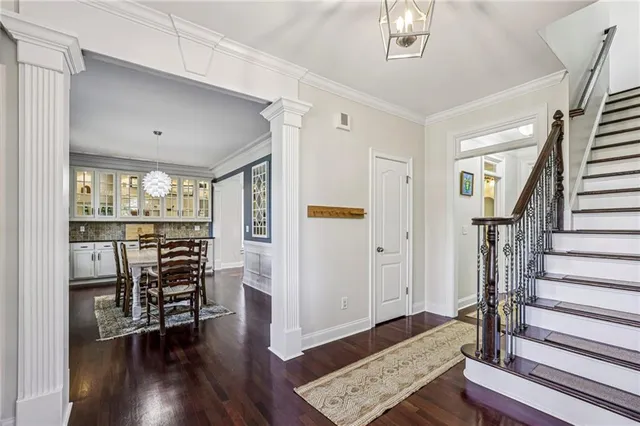a view of a hallway with wooden floor and a dining room