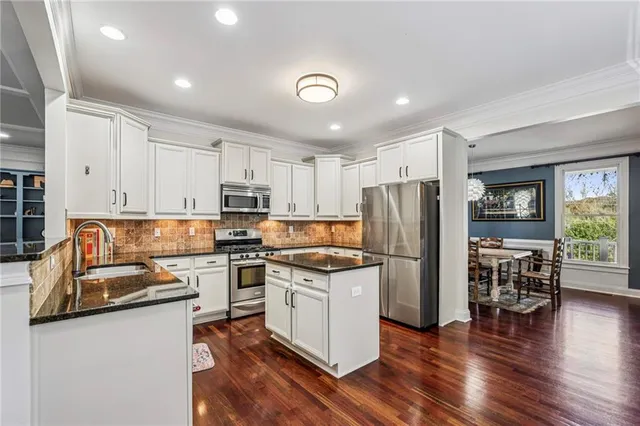 a kitchen with granite countertop a refrigerator stove top oven and sink