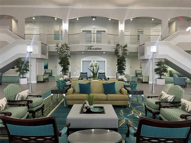 a living room with furniture a fireplace and a chandelier