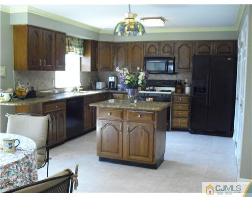 4306 Springbrook Drive Edison, NJ 08820 - Photo 2 of 2 a kitchen with stainless steel appliances granite countertop a sink stove and refrigerator