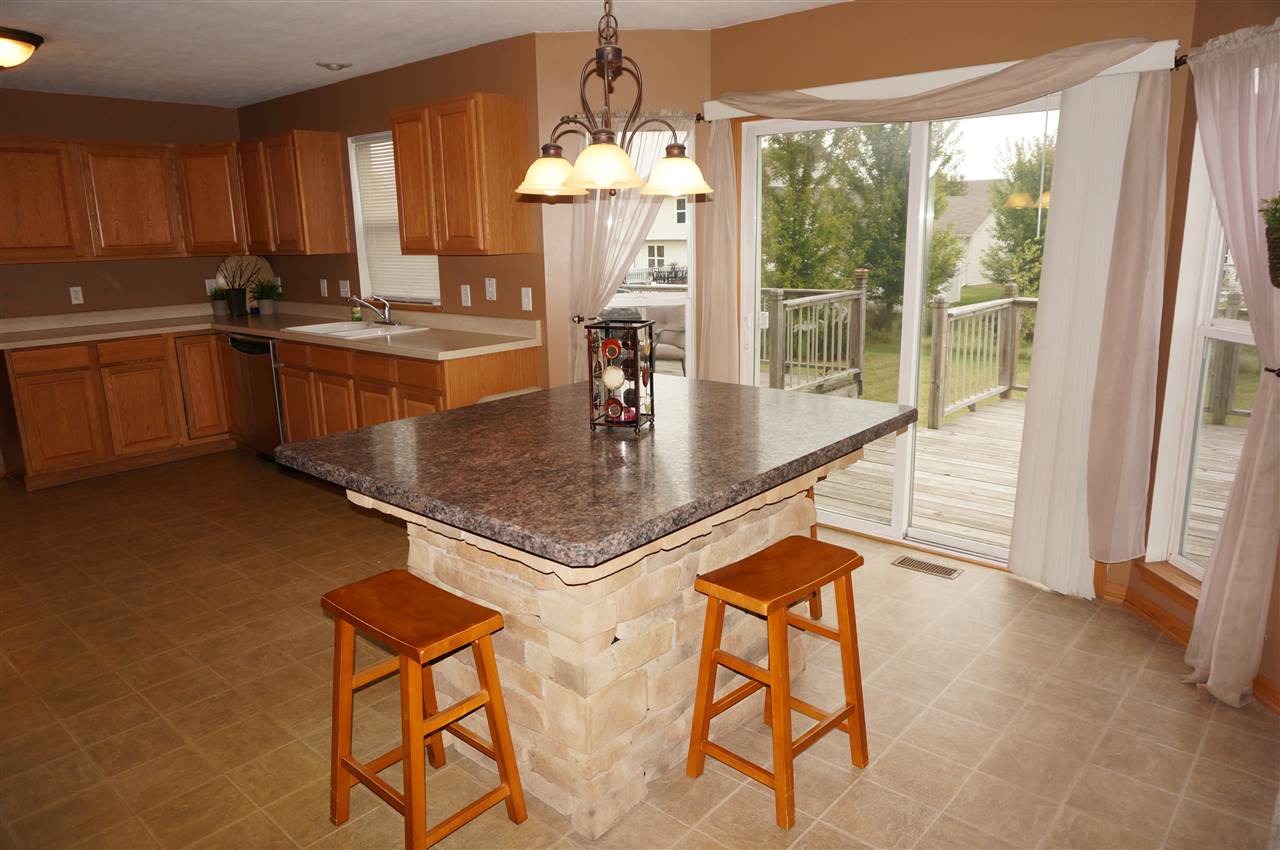 1439 Rock Island Road Davis Junction, IL 61020 - Photo 14 of 25 a kitchen with stainless steel appliances granite countertop a stove top oven a sink dishwasher and cabinets with wooden floor