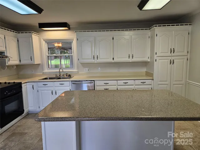 a kitchen with stainless steel appliances granite countertop a refrigerator a stove and a sink