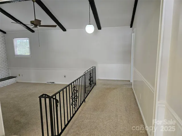 a view of a hallway with wooden floor and windows