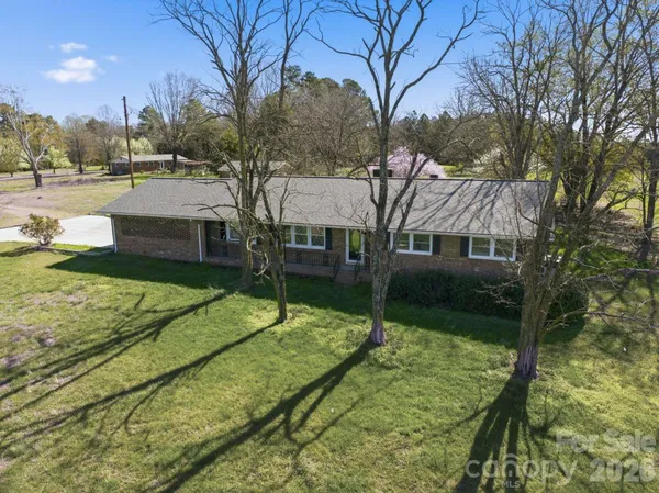 a view of a house with a yard and tree s