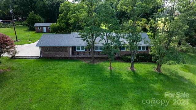a view of a house with a backyard and a tree