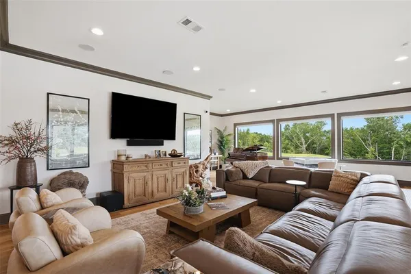 a bedroom with a large bed a flat tv screen and dresser