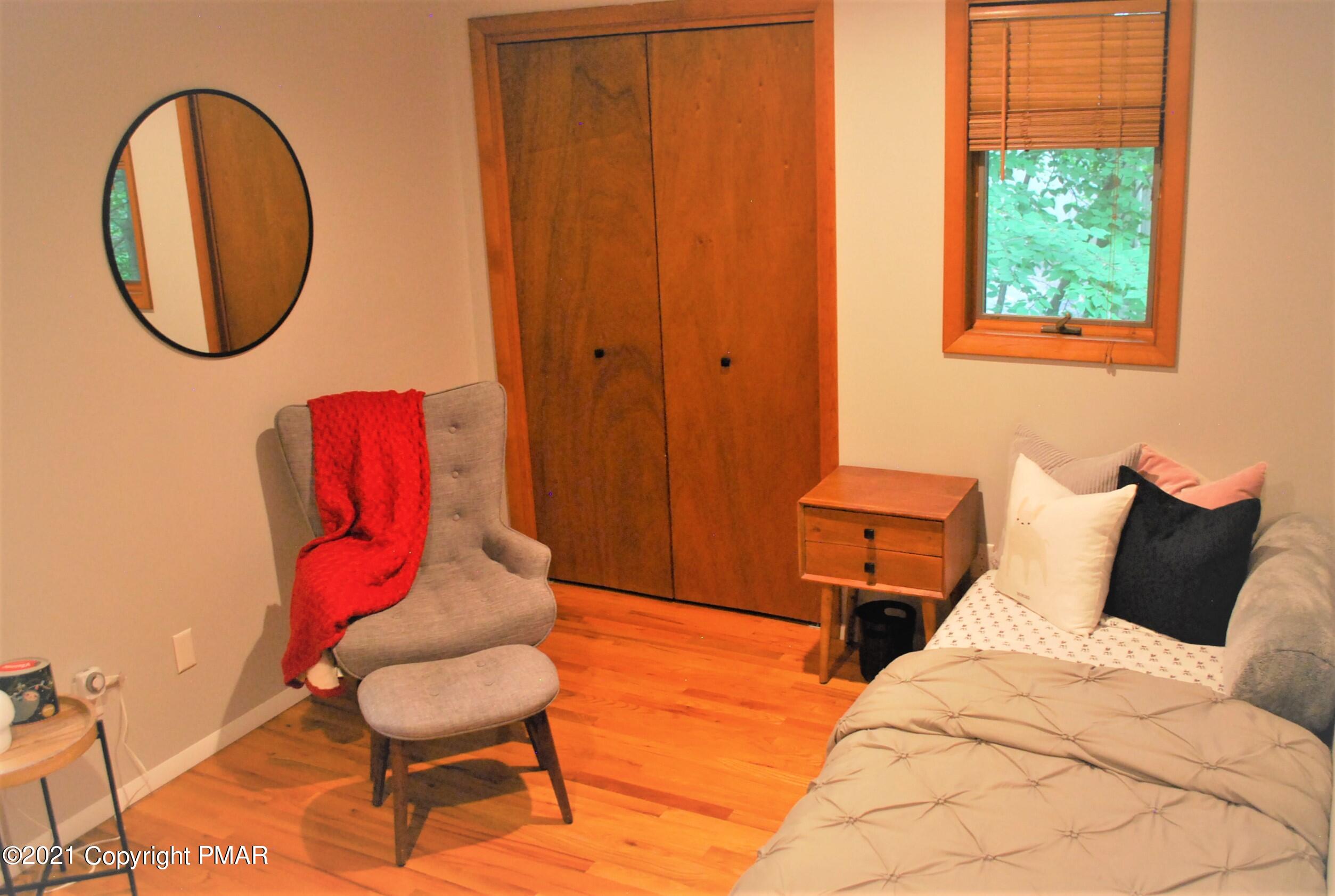 178 Edinburgh Road Bushkill, PA 18324 - Photo 30 of 54 a bedroom with a bed a chair and a potted plant