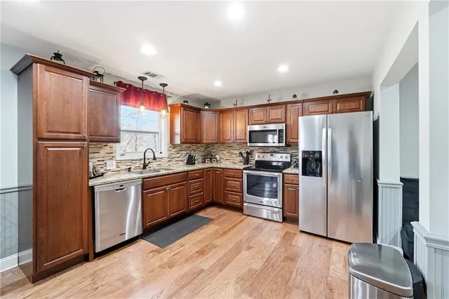 a kitchen with granite countertop stainless steel appliances a refrigerator sink and microwave