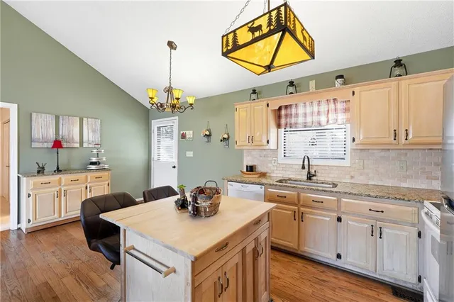 a kitchen with a sink cabinets and wooden floor