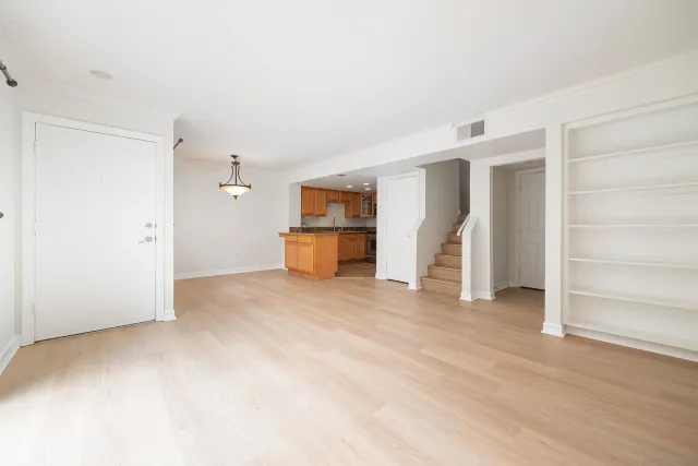a view of empty room with wooden floor and window