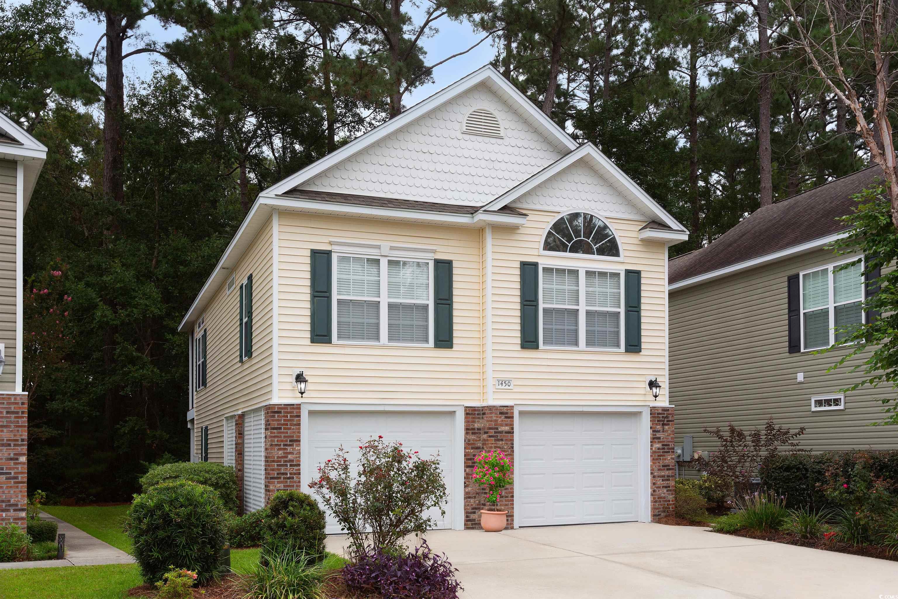 View of front of property with brick siding, concrete driveway, and an attached garage