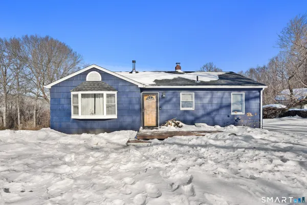 a view of a house with a yard covered in snow