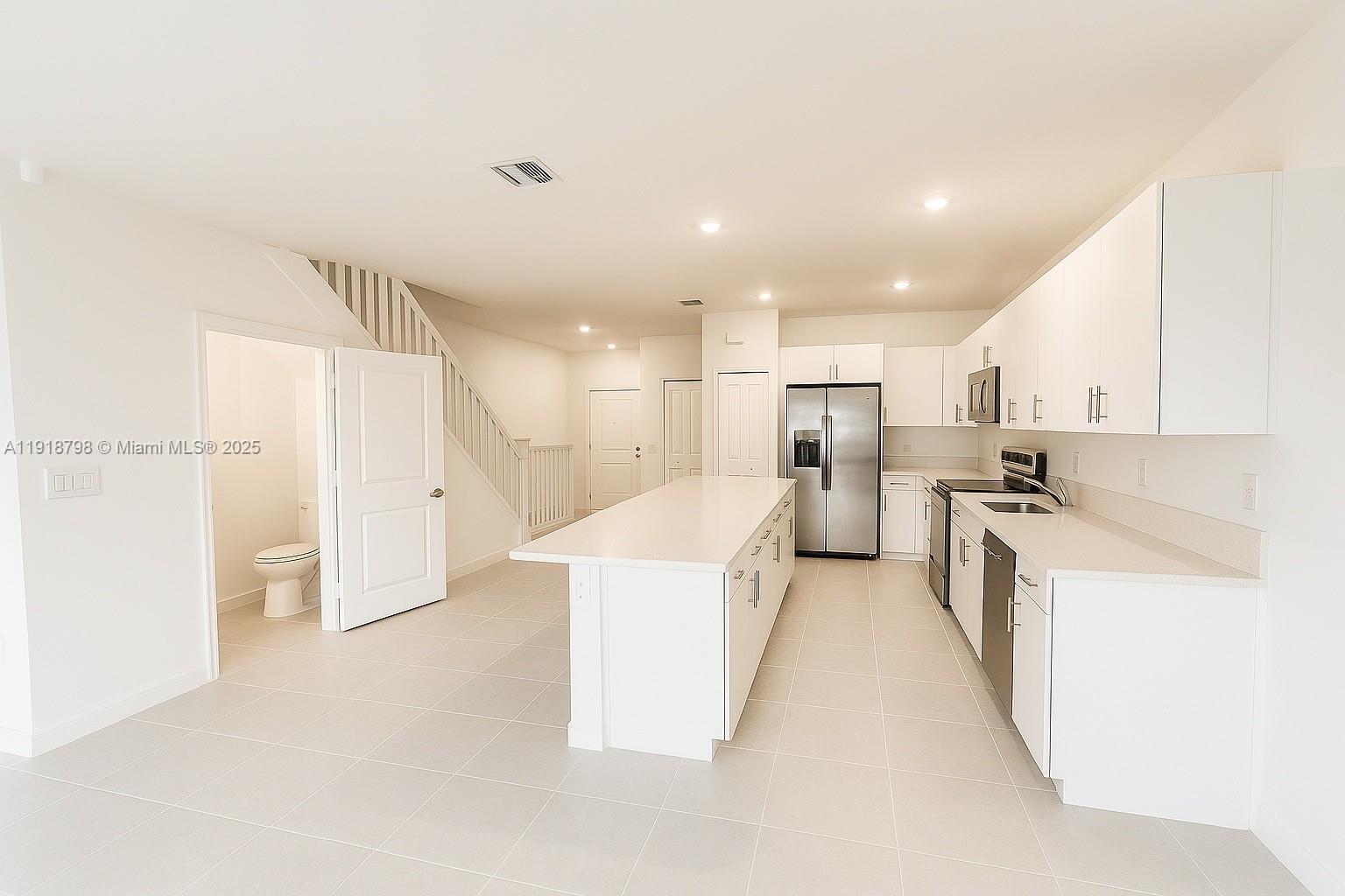 25564 Southwest 108th Avenue, Unit 25564 Homestead, FL 33032 - Photo 4 of 17 a large kitchen with a lot of white cabinets