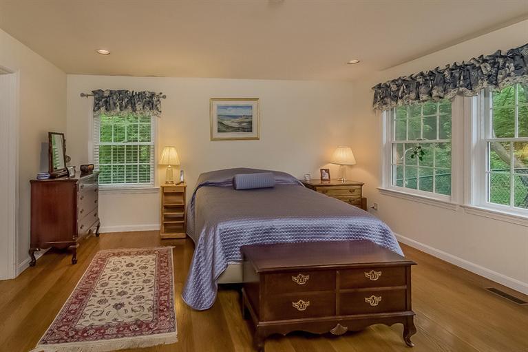 53 Sandy Neck Road East Sandwich, MA 02537 - Photo 14 of 28 a bedroom with a bed and wooden floor