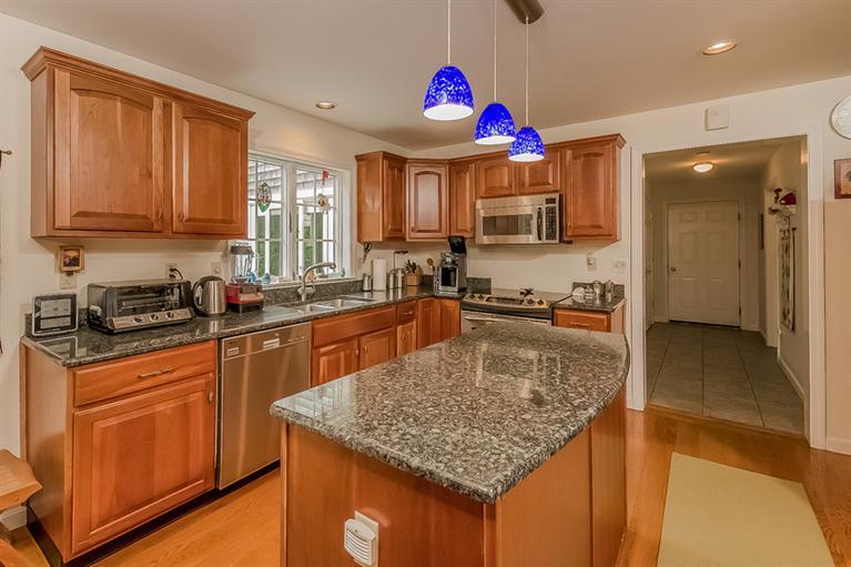 53 Sandy Neck Road East Sandwich, MA 02537 - Photo 9 of 28 a kitchen with kitchen island granite countertop a stove sink and cabinets