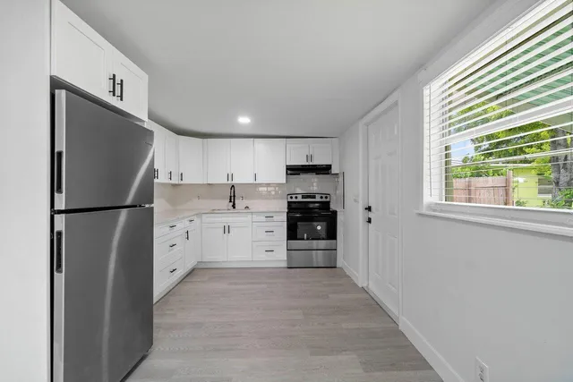a kitchen with stainless steel appliances a refrigerator sink and cabinets