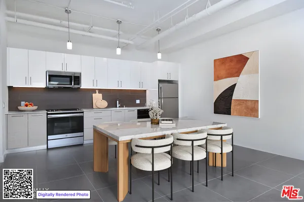 a kitchen with stainless steel appliances a stove a sink a microwave a dining table and chairs