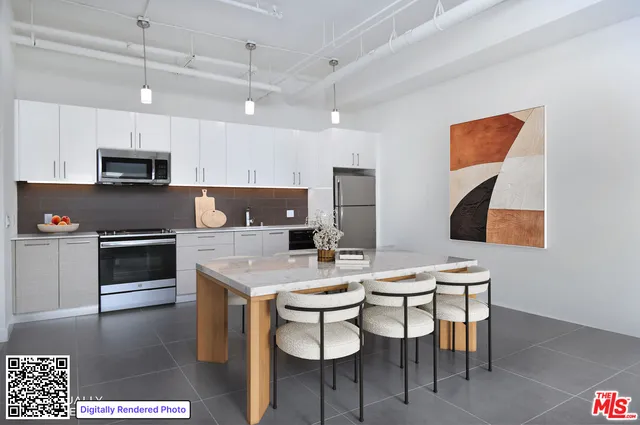 a kitchen with stainless steel appliances a stove a sink a microwave a dining table and chairs