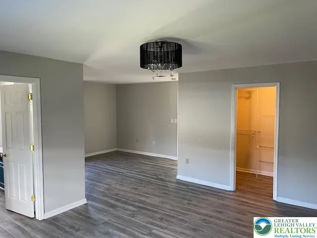 an empty room with wooden floor and cabinet