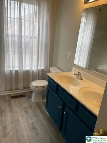 a bathroom with a granite countertop sink toilet and mirror