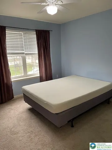 a bed sitting in a bedroom next to a window