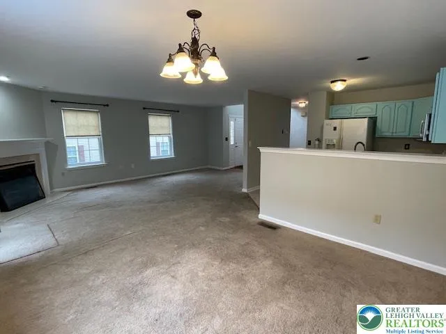 a view of a kitchen with a sink and chandelier