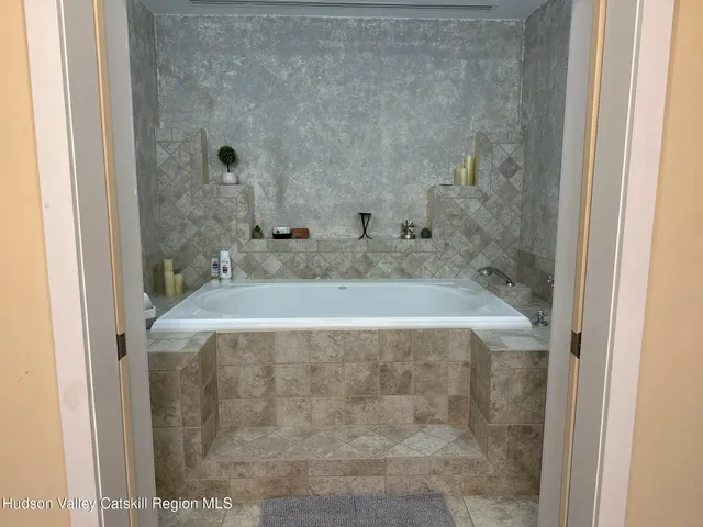 a bathroom with a granite countertop sink a mirror and shower