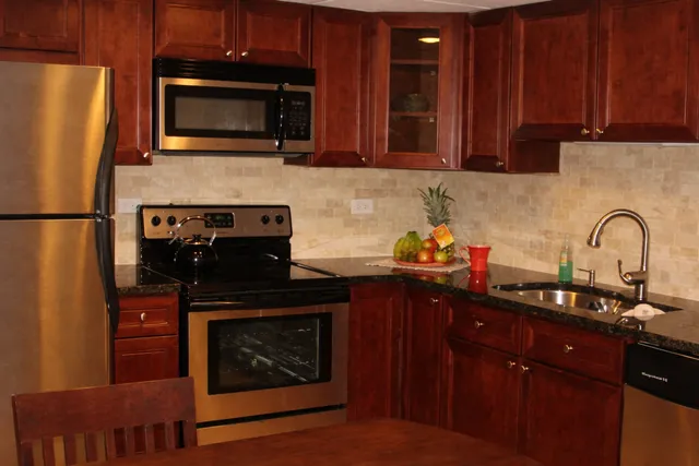 a kitchen with stainless steel appliances granite countertop a stove microwave and refrigerator