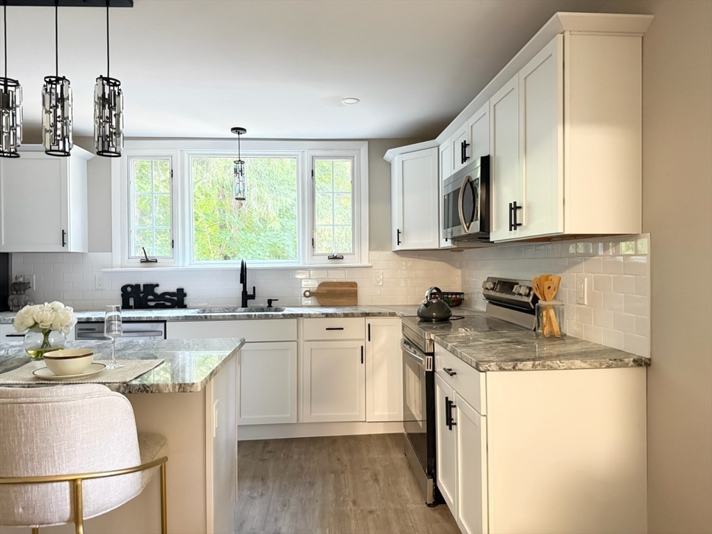 37 Bridge Street Monson, MA 01057 - Photo 3 of 35 a kitchen with a stove a sink and white cabinets