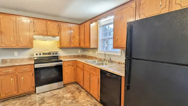 a kitchen with stainless steel appliances granite countertop a refrigerator sink and cabinets