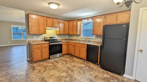 a kitchen with a refrigerator sink and cabinets