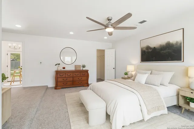 a bedroom with a large bed and a chandelier