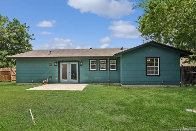 a front view of a house with a yard and trees
