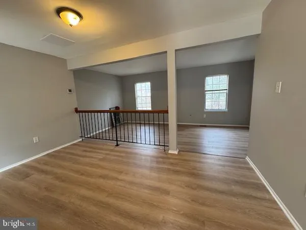 a view of a room with wooden floor and windows