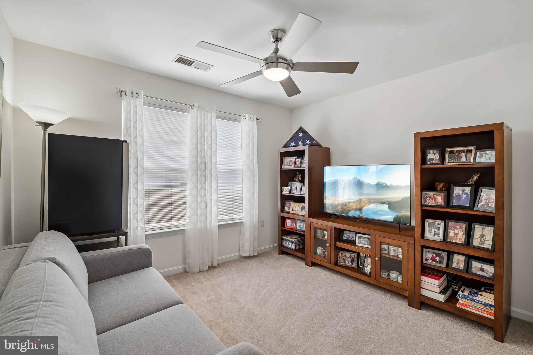 43351 Fullerton Street Ashburn, VA 20147 - Photo 25 of 41 a living room with furniture a floor to ceiling window and a flat screen tv