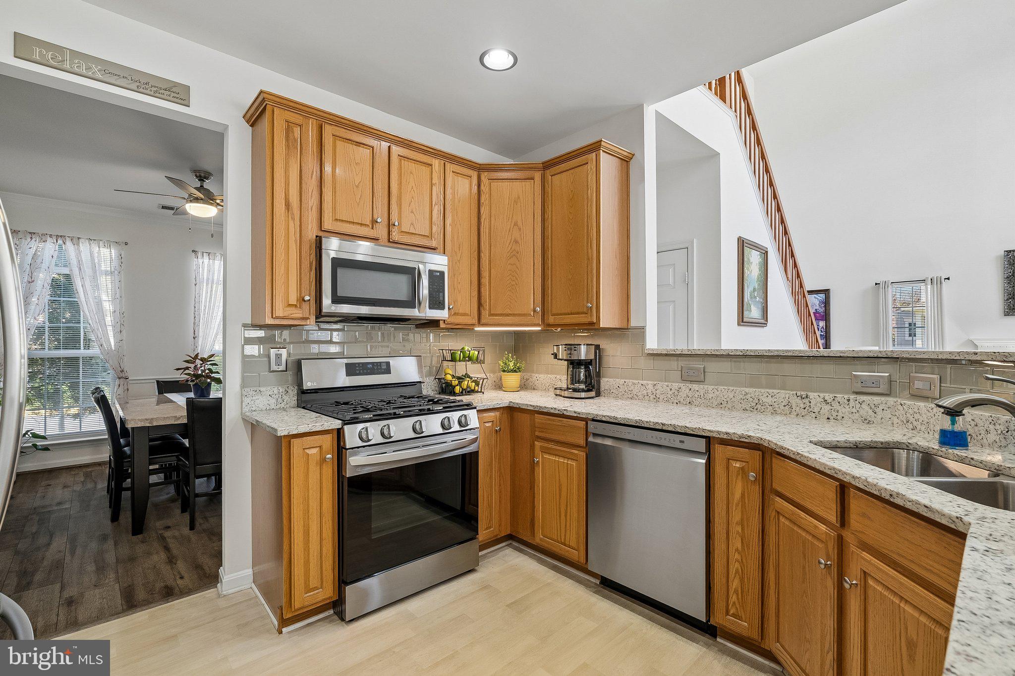 43351 Fullerton Street Ashburn, VA 20147 - Photo 8 of 41 a kitchen with stainless steel appliances granite countertop a stove a sink and a microwave