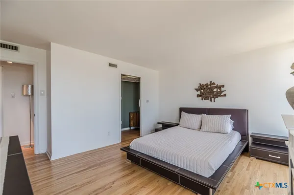 a bedroom with a bed and wooden floor
