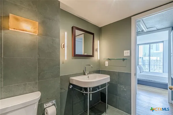 a bathroom with a sink a toilet and a mirror