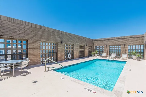 a swimming pool with outdoor seating and yard