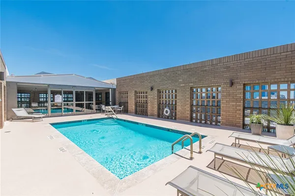 a view of a house with swimming pool and porch with furniture