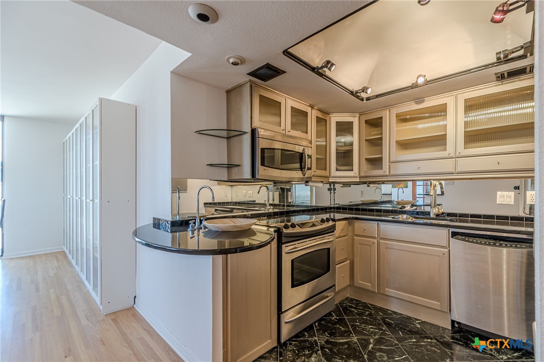 1122 Colorado Street, Unit 1409 Austin, TX 78701 - Photo 8 of 32 a kitchen with stainless steel appliances granite countertop a stove and a sink