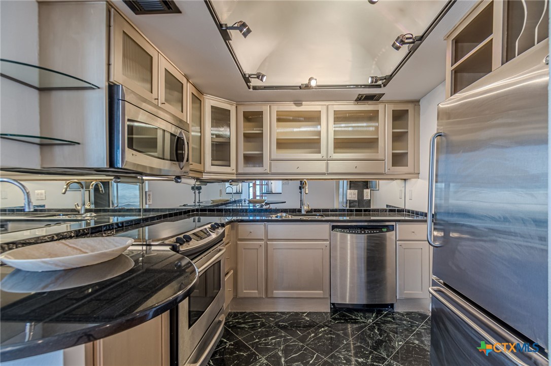 1122 Colorado Street, Unit 1409 Austin, TX 78701 - Photo 9 of 32 a kitchen with stainless steel appliances granite countertop a stove and a sink