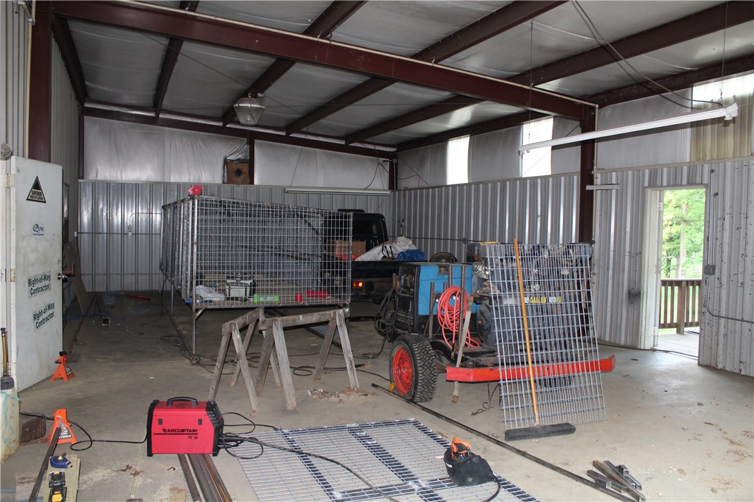 158 Ragon Road Tilly, AR 72679 - Photo 35 of 51 Spacious metal-frame building featuring concrete flooring, corrugated metal walls, and exposed steel beam ceiling