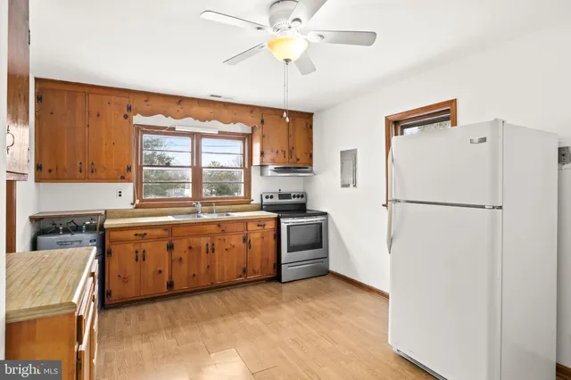 a large kitchen with a refrigerator a stove top oven a sink and dishwasher