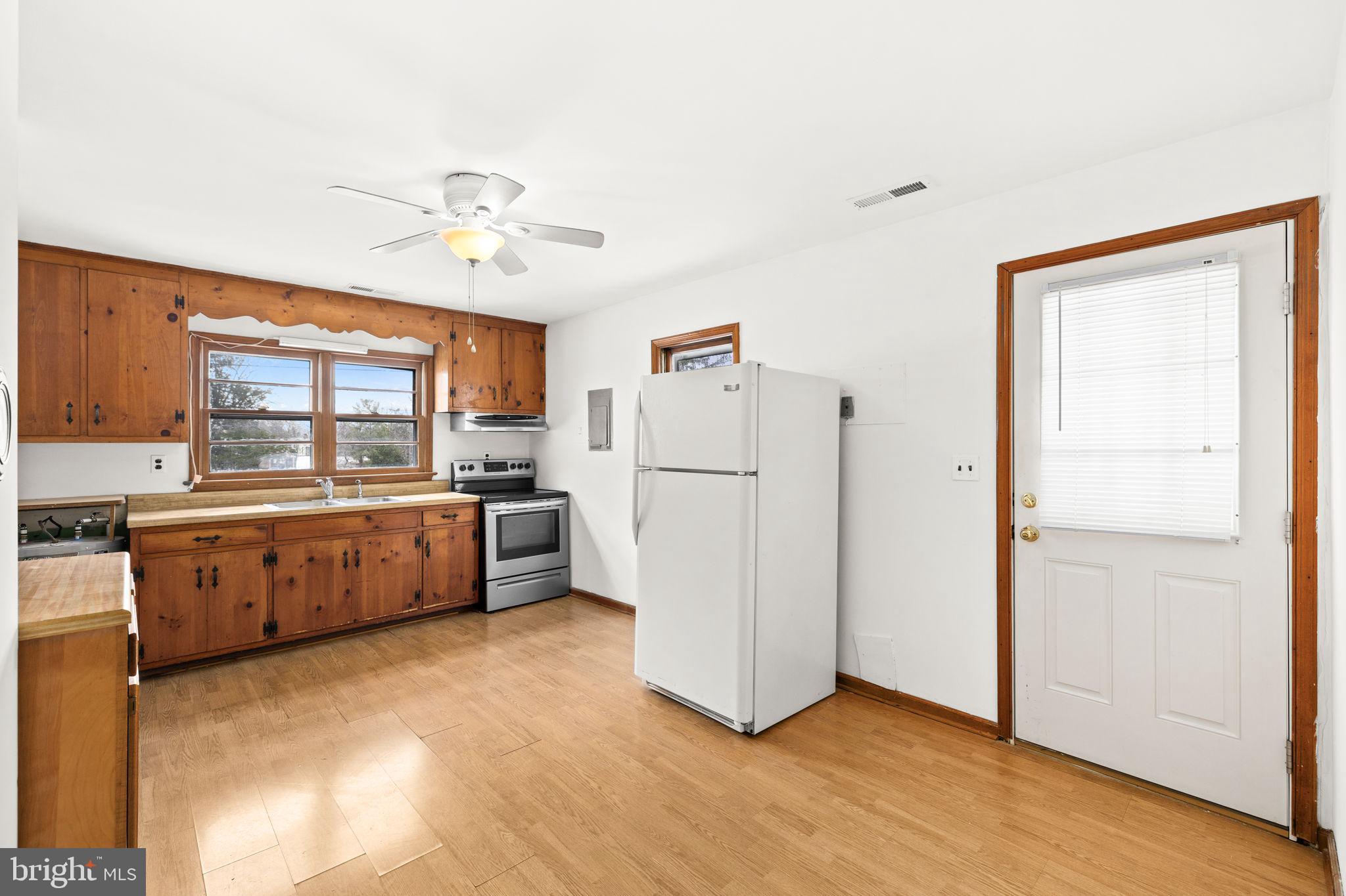 11604 Maple Tree Court Orange, VA 22960 - Photo 12 of 39 a kitchen with refrigerator a stove a sink and white cabinets with wooden floor